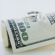 Wedding ring on one hundred dollar bill. Photographe : Jamie Grill