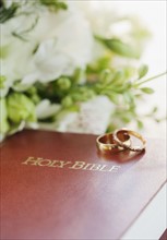 Two wedding rings on bible, studio shot. Photographe : Jamie Grill