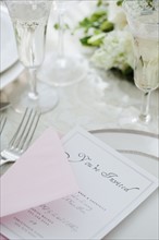 Wedding invitation on table setting, studio shot. Photographe : Jamie Grill