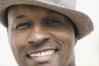 Portrait of man wearing hat, smiling. Photographe : PT Images