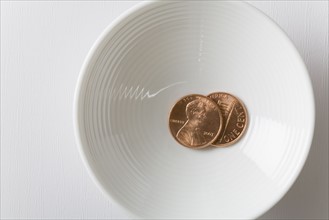 Two one cent coins in bowl. Photographe : Kristin Lee