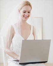 Young bride surfing on internet. Photographe : Jamie Grill