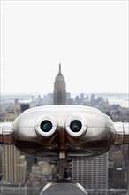 Coin operated binoculars pointing at Empire State Building, New York City, New York, USA.