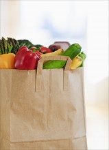 Paper bag filled with vegetables.