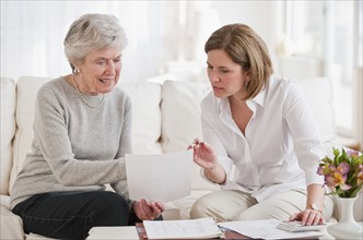 Mature woman giving financial advice to senior woman.