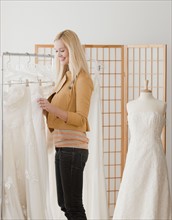 Young woman looking for wedding dress in bridal shop. Photographe : Jamie Grill
