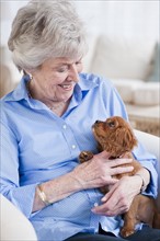 Senior woman hugging puppy.