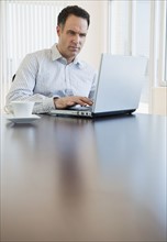 Mature businessman using laptop.