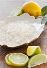 Bowl of bath salt and slices of citrus on table.