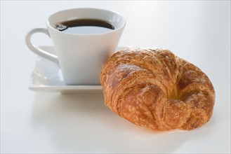 Studio shot of coffee and croissant.