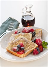 Studio shot of French toast with fruits and syrup.