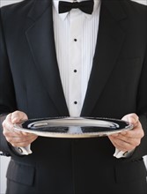 A server holding a silver tray.