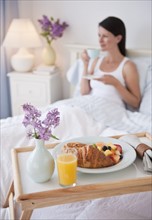 A man bringing a woman breakfast in bed.