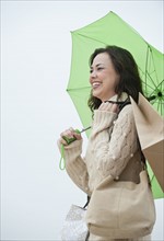 A woman with shopping bags in the rain.