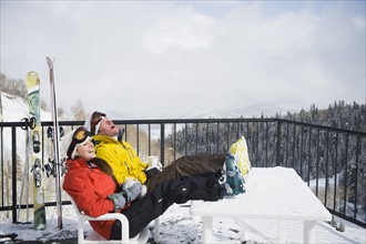 A couple relaxing on deck at ski resort