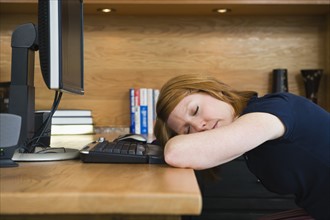 A woman sleeping in a home office