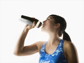 Woman drinking water while training