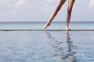 A woman standing on the edge of a swimming pool