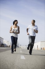 A couple running on road outdoors