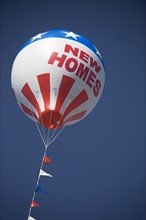 A large promotional balloon that says New Homes