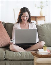 Woman using laptop in living room.