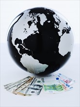 A globe with international bank notes.
