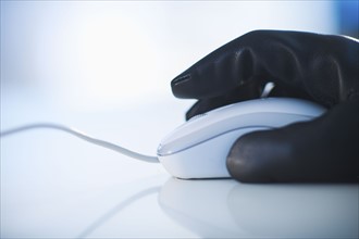 A gloved hand on a computer mouse.