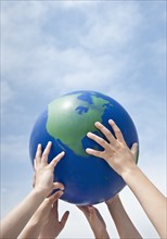 Children holding a globe.