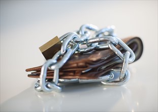 A padlock and chain around a wallet.