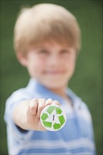 Young boy holding recycling button.