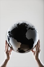 Hands holding a globe.