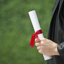 A graduate holding a diploma.