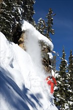 A snowboarder coming off a cliff