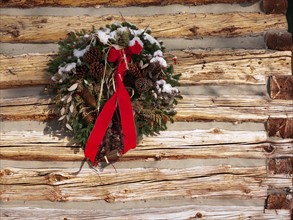 A Christmas wreath on a cabin wall