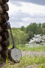 A banjo leaning against the wall of a cabin