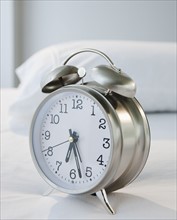 An alarm clock on a bed