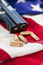 A handgun and ammunition on the American flag