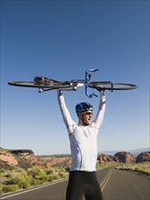 Biker on the road holding bike up