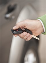 A hand holding a car remote key.
