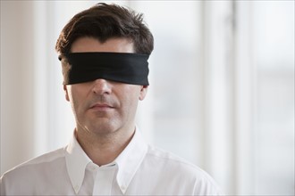 Businessman wearing blindfold.
