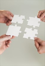 Hands holding puzzle pieces.
