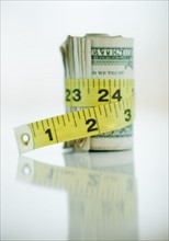 A measuring tape around bank notes.