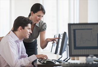 Two business people using a computer.