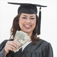 A graduate holding money.