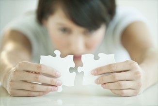 Woman holding puzzle pieces.