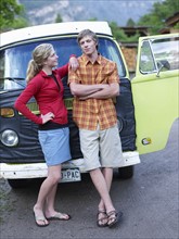 Young couple standing in front of van