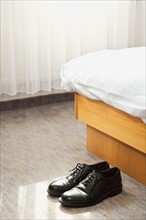Shoes in front of bed
