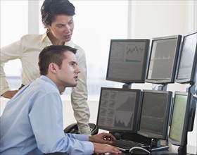 Traders studying computer screens.