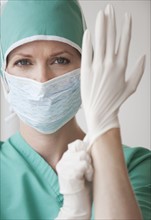 Female doctor putting on gloves.