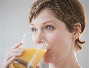 Woman drinking orange juice.